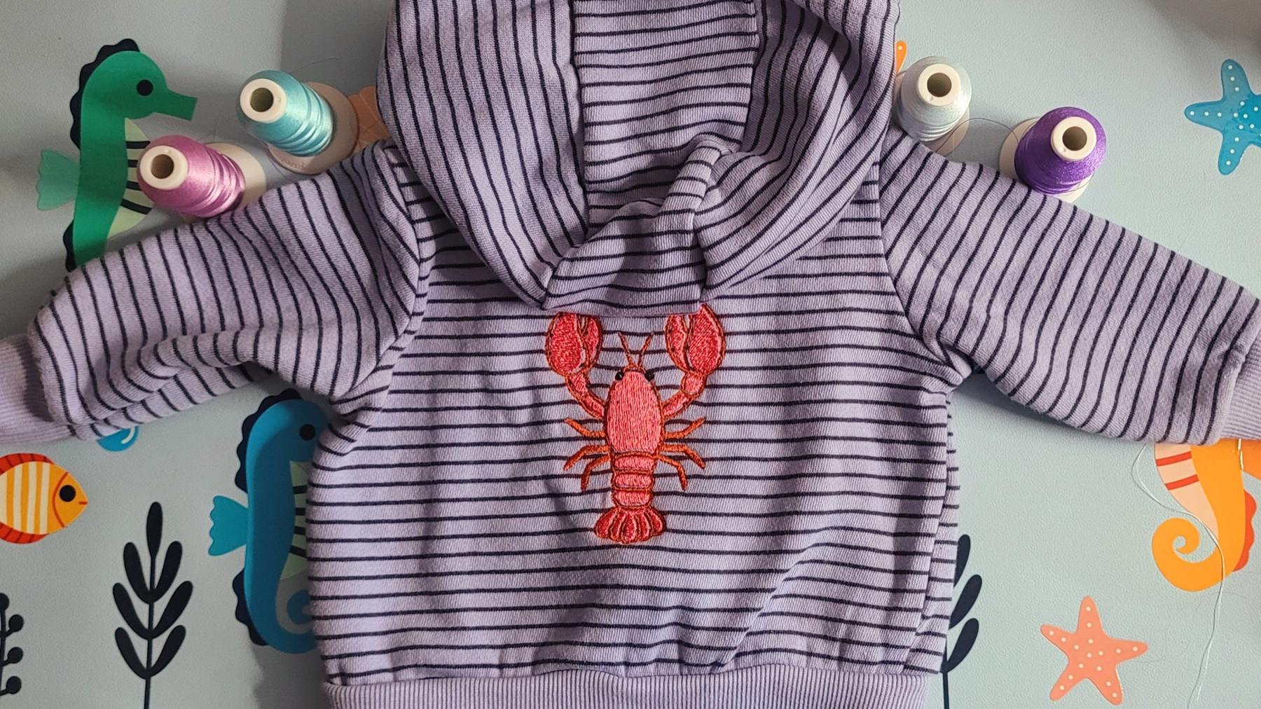 Lobster embroidery on a striped baby hoodie